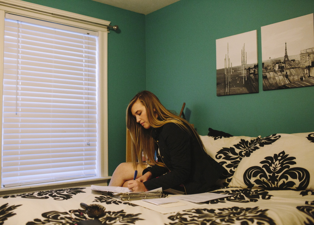 Krista Boylen completes homework in her bedroom in Gorham last month. The high school senior is looking hard at tuition costs as she selects a college. Her parents, Jen and Bob Boylen, will assist with some of the tuition bill and the also expect to help three other children who also plan on attending college. Jen and Bob Boylen said they hope their daughter will make a school choice based upon both a feeling and financial perspective, but because their other children will also likely attend university, they know it will be difficult to pay four children’s tuition bills outright.