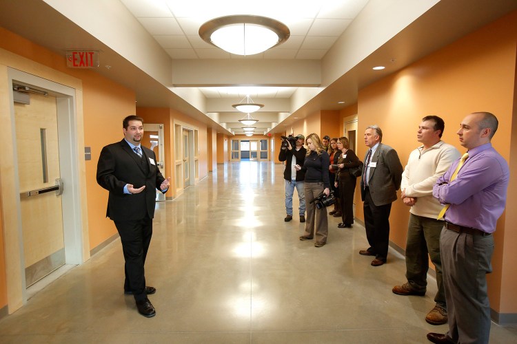 Ken Cianchette, left, project manager with ELC Management, the company that oversaw construction of the building in South Portland that will house offices of Maine's Department of Health and Human Services and Department of Labor, gives a tour of the building on Monday.  Gregory Rec/Staff Photographer