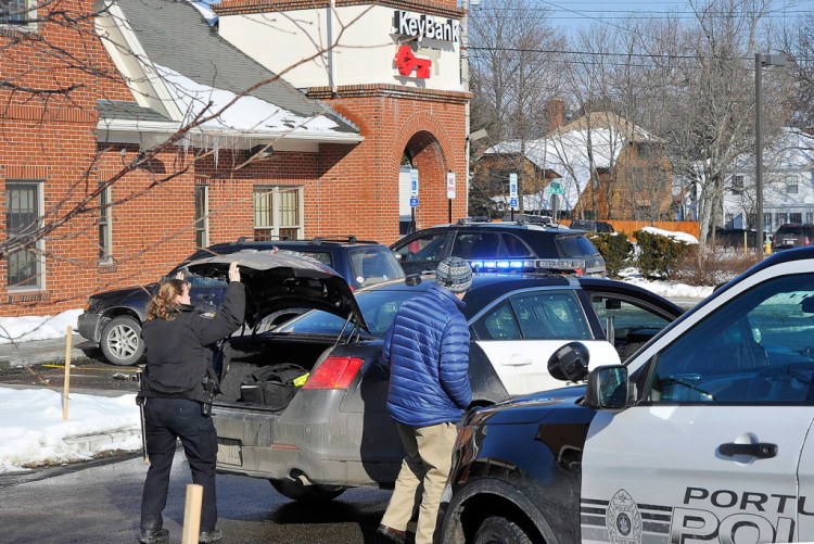 Portland police Officer Marjorie Clavet prepares to interview a witness after Friday's robbery at the Key Bank branch at 400 Forest Ave. in Portland. Gordon Chibroski/Staff Photographer