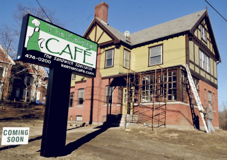 Keith Moore, of Up Country Painters, gets off a ladder Tuesday while working on the new location of the Kel-Mat Cafe on Madison Avenue in Skowhegan.