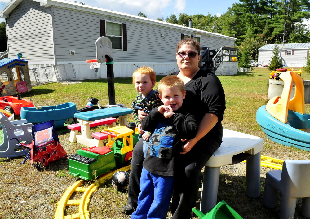 Dawn Zammuto holds her grandchildren Allen, left, and Dominic outside the home she rents in Norridgewock on Sept. 17, 2014. Zammuto was threatened with eviction by the home’s owner, who claimed she violated a “no pet” rule because she allowed her daughter and her daughter’s service dog to stay a few days in August.