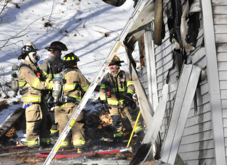 Staff photo by David Leaming
Firefighters work around the rear section of an Oakland home where fire may have started that destroyed the residence on Thursday.