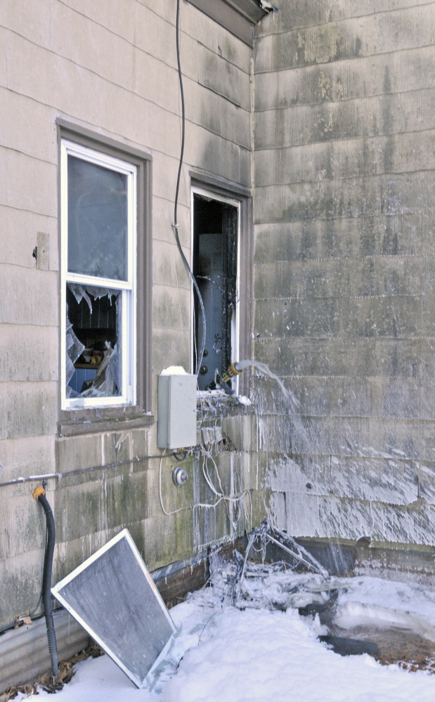 Staff photo by Joe Phelan
Water runs from a house after Winthrop fire department put out a fire Saturday morning at a four-unit apartment house at 100 Route 133 in Winthrop.