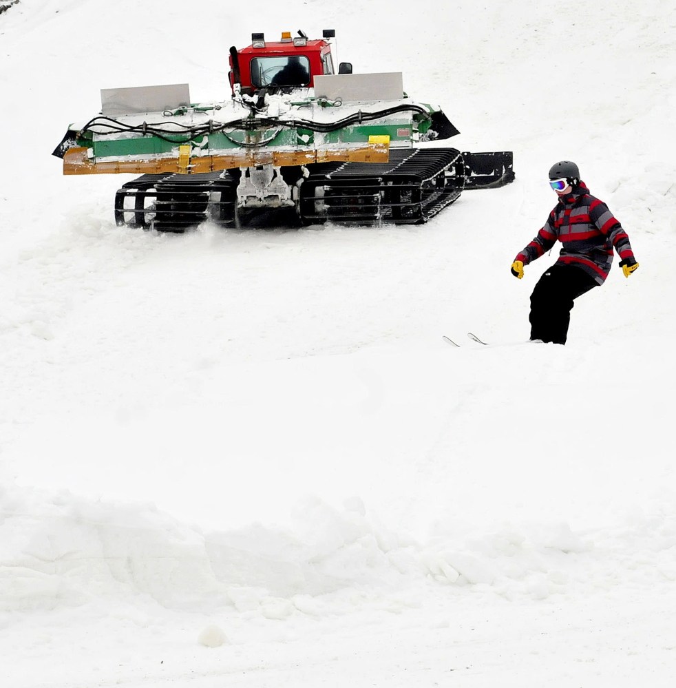 Nicholas Morris, of Canaan, skis over a small jump as Eaton Mountain Ski and Snowtubing company owner Dave Beers grooms trails on Sunday.