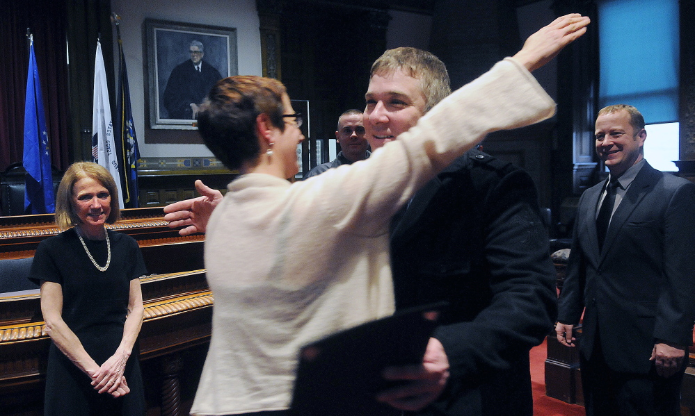 Veterans advocate Laura Allen, center, hugs veteran Jason Richardson Monday during graduation ceremonies for the Co-Occuring and Veterans courts in Augusta. Richardson was one of 14 people who completed the intensive program administered at Kennebec County Superior Court by Justice Nancy Mills, at left.