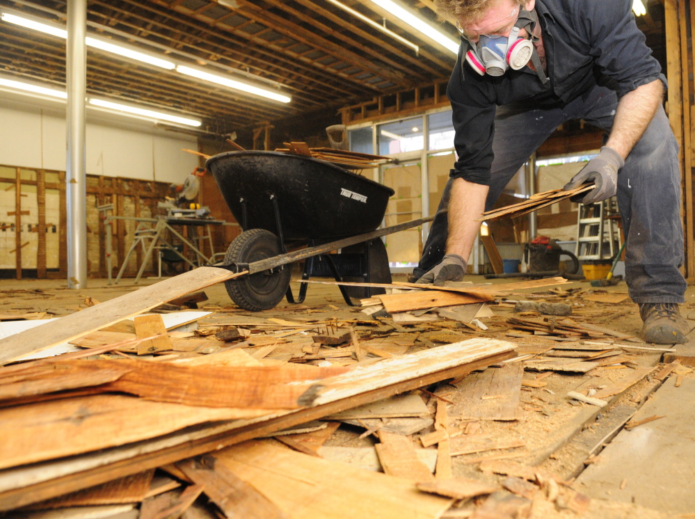 Esben Raahede picks up demolition debris Tuesday in the space that will become the Gardiner Food Co-op & Cafe on Water Street in downtown Gardiner.