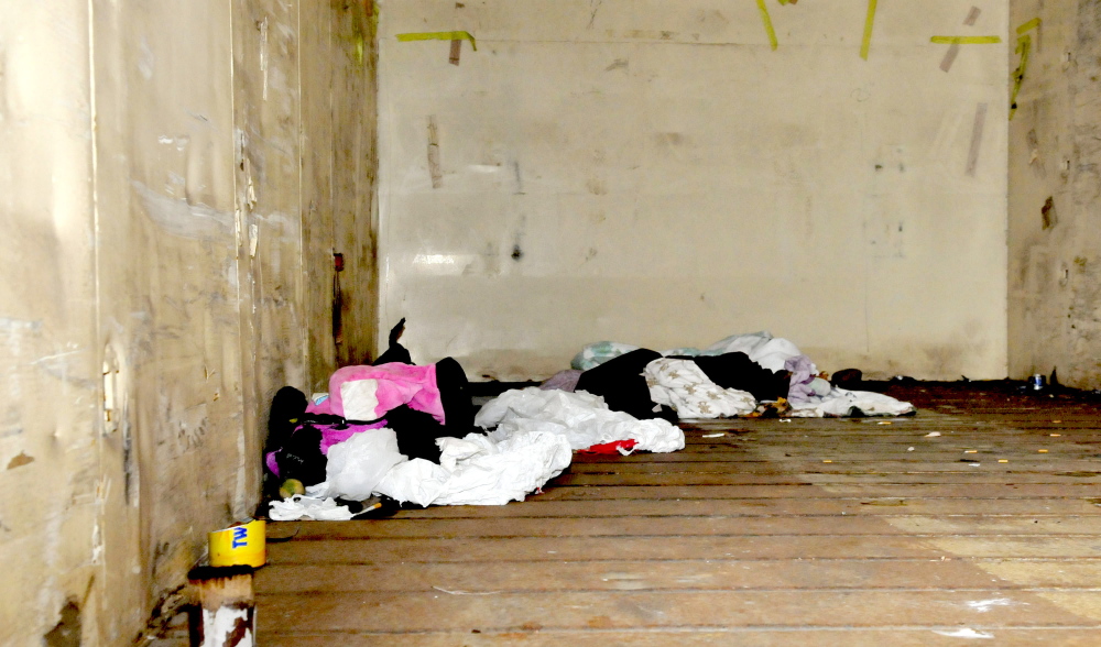 Bedding, clothes, makeshift candles and cigarette butts lie discarded in an open Pan Am railroad car on a side track beside Railroad Avenue in Oakland. Nearby residents Daniel and Jennifer Lally have complained that people are entering and using the cars at night.