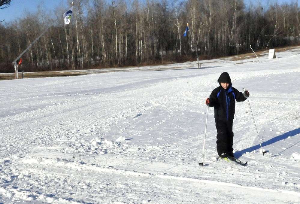 Sebastien Rail, a member of the Central Maine Ski club, skis near snow-making guns, at left, at the Quarry Road Recreation Area in Waterville on Thursday. The snowmaking equipment is in part responsible for plenty of snow at the site.