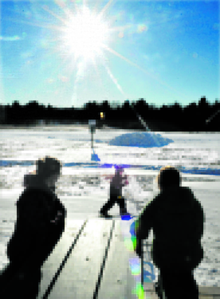 Staff photo by David Leaming
Central Maine Ski club member Sebastien Rail skis on abundant snow past the warming yurt at the Quarry Road Recreation Area in Waterville. Watching are Claire Polfus, left, and Dee Powers.