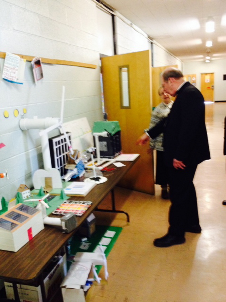 Normal:Bishop Robert Deeley with Principal Bonnie McGann  and students at St. John Regional Catholic School in Winslow Monday.
Plain Text: