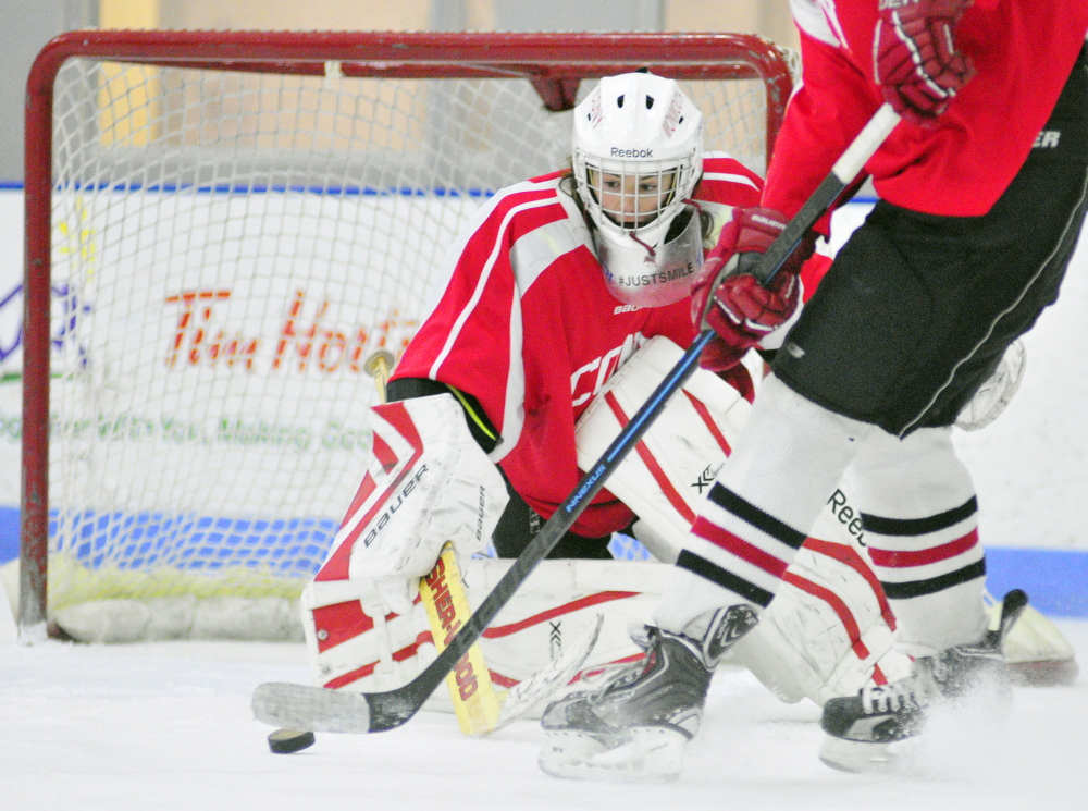 staff photo by Joe Phelan 
 Cony/Monmouth goalie Tommy Small blocks a shot during an optional practice Friday at the Bank of Maine Ice Vault in Hallowell.