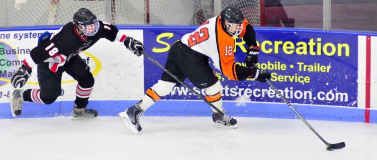 Maranacook/Winthrop’s Matt Ingram, left, and Gardiner’s Jake Folsom chase after a puck in the corner during a game on Saturday at the Bank of Maine Ice Vault in Hallowell.