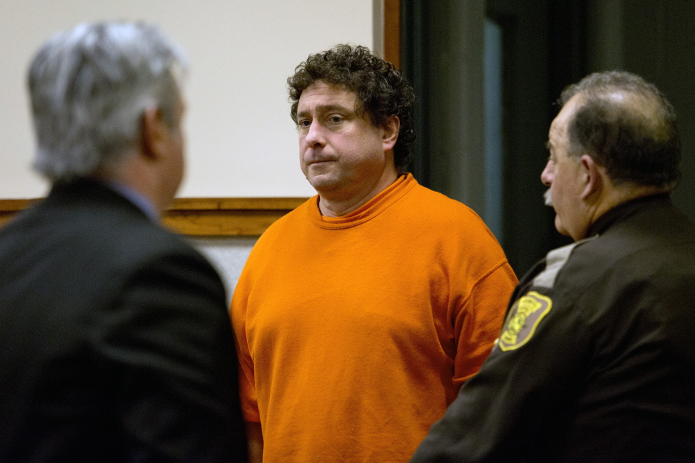 Anthony J. Sineni III, a Standish attorney, is led into the Cumberland County Courthouse on Monday to face charges of violating a protection-from-abuse order and conditions of his release. Gabe Souza/Staff Photographer