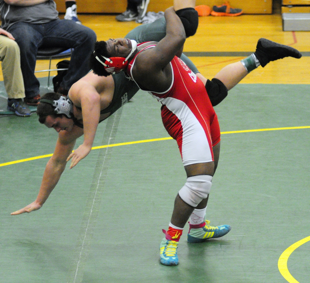 Oxford Hills’ Creighton Medeiros, left, gets thrown by Cony’s Max Storey in the 220-pound finals during the Eastern A wrestling championships Saturday at Oxford Hills. Storey won.