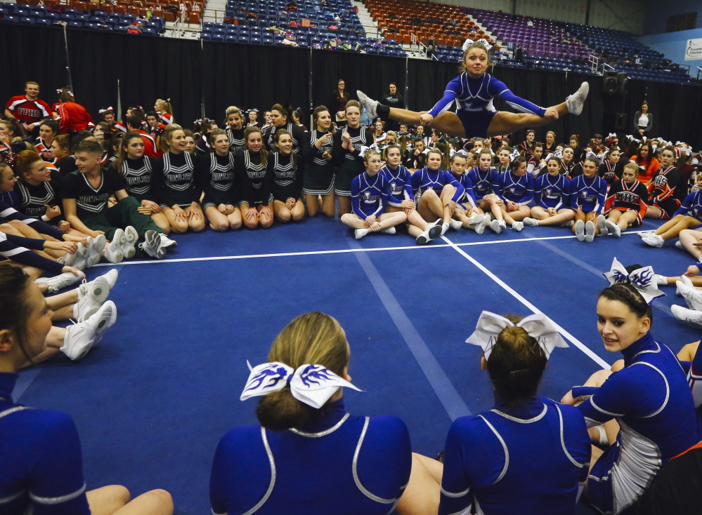 Maine Sunday Telegram photo by by Whitney Hayward 
 Lawrence high school sophomore Sierra Hawkes jumps into the air while teammates watch after the Class A state championships Saturday.