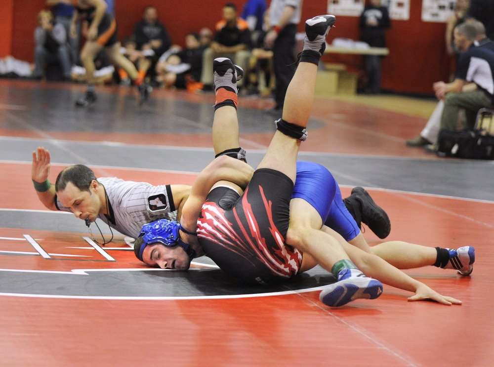 Maine Sunday Telegram photo by John Ewing 
 Referee Kyle Powers signals a pin by Erskine's Zach Isbell, top, over Wells' Nolan Potter in a 160-pound match Saturday at the Western B championships in Wells.