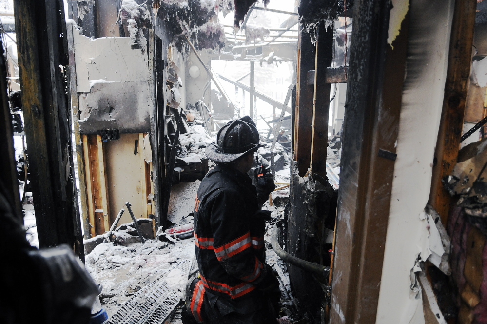 A firefighter crawls into Highland Terrace in Gardiner on Thursday, a day after fire destroyed about half of the senior housing complex. Gardiner Fire Chief Al Nelson said Sunday the cause of the fire is determined to be accidentla, and likely an electrical issue.