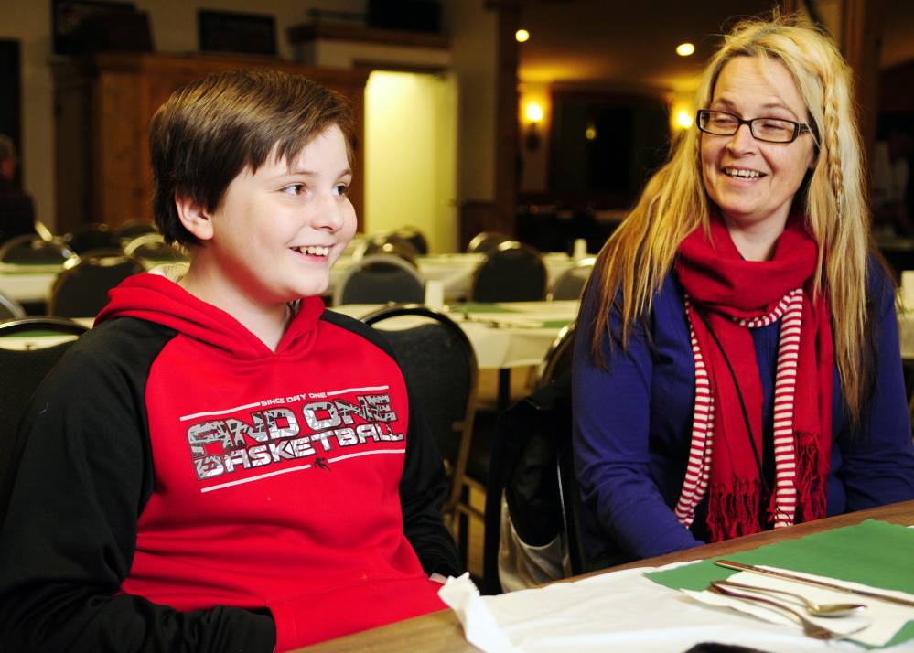 Malachi Walo, left, and his mother Michelle Hartman share a laugh Thursday during an interview before an awards presentation honoring Walo’s efforts to save his family from a January fire.