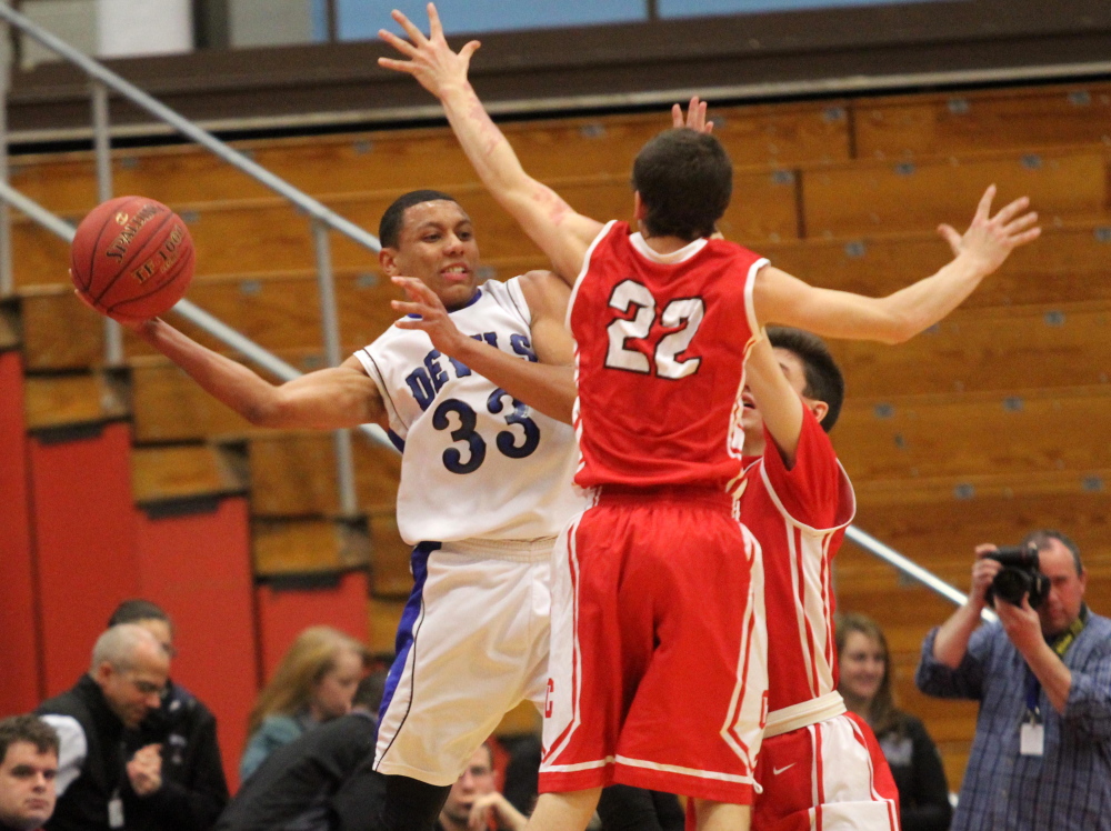 Cony High School’s Keith Briggs (22) and Matthew Murray put pressure on Lewiston’s Isaiah Harriss (33) during the first half of an Eastern A quarterfinal at the Augusta Civic Center on Monday. Cony lost 89-51.