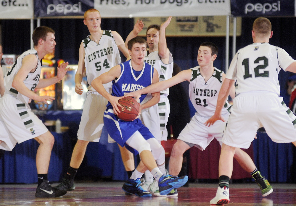 The Winthrop High School defense swarms Madison’s Chase Malloy during a Western C quarterfinal game Monday night at the Augusta Civic Center.