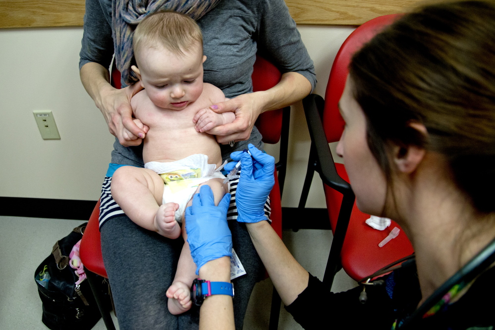 Bethany Hickey holds Alexander as he is vaccinated by clinical assistant Laura Boyer at Intermed Pediatric Care. Hickey worries about giving her children too many shots all at once, but nevertheless believes in the value of vaccinations. “If enough people go without vaccinations, it’s a health risk to the general population,” she said. Gabe Souza/Staff Photographer