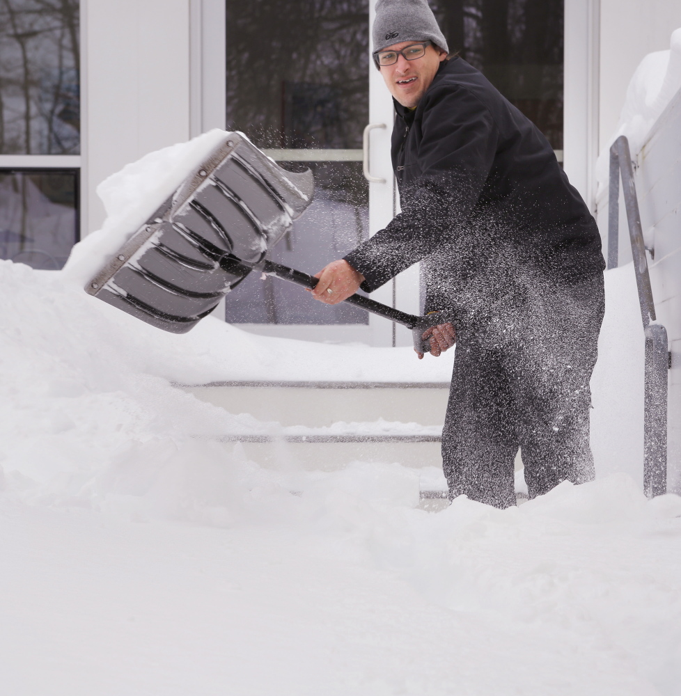 Travis Philbrook clears a walkway Tuesday at the Freeport Community Center. He works for the center and shovels for center volunteers who can’t get out of their driveways.