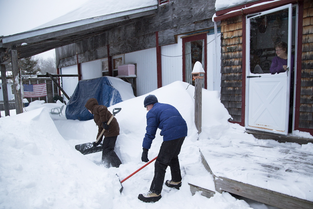 Boy Scouts clear snow from around Nancy Taylor's house in Freeport. Taylor feared that she couldn’t get out of the home if she had a second heart attack.