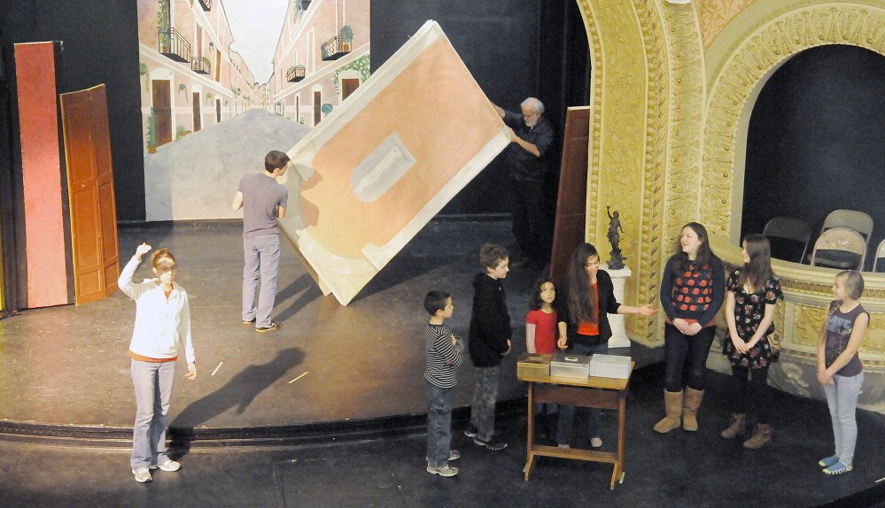 Home-school students, right, rehearse Shakespeare’s “The Merchant of Venice” Monday as sets are arranged on the stage at Cumston Hall in Monmouth. The play opens Thursday.