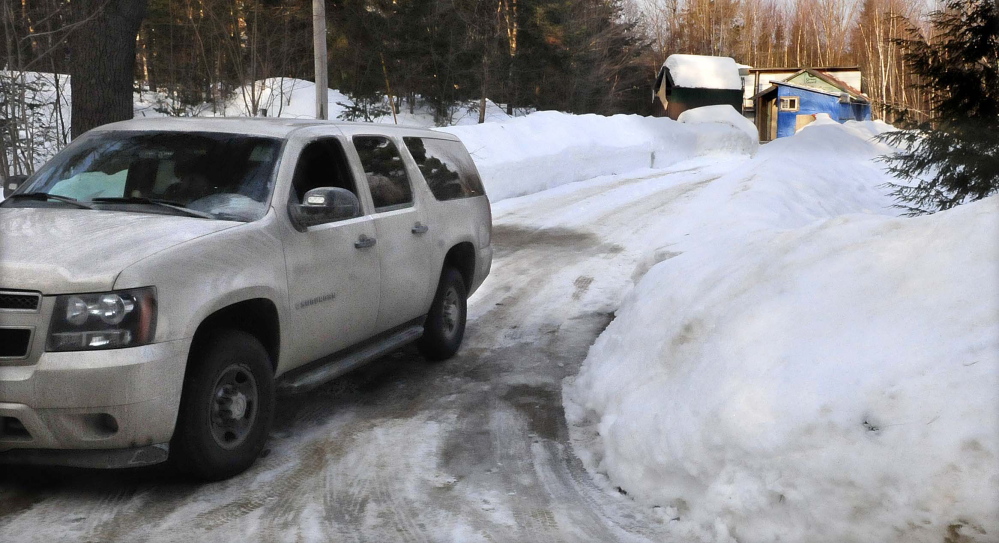 A Maine State Police trooper sits in a cruiser at the end of the driveway at 188 Rutland Road in Troy on Sunday. Police discovered the body of Steven Hodgdon at the rural home early Saturday morning.