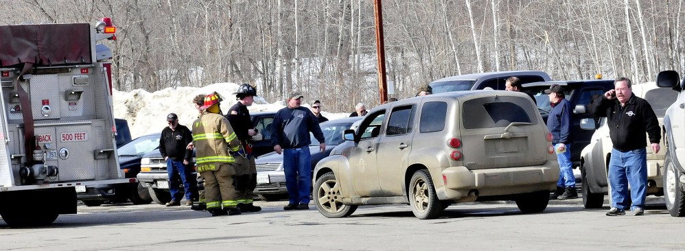 Waterville firefighters speak with employees of Motor Supply company after they evacuated the business following the smell natural gas inside the building on Tuesday.
