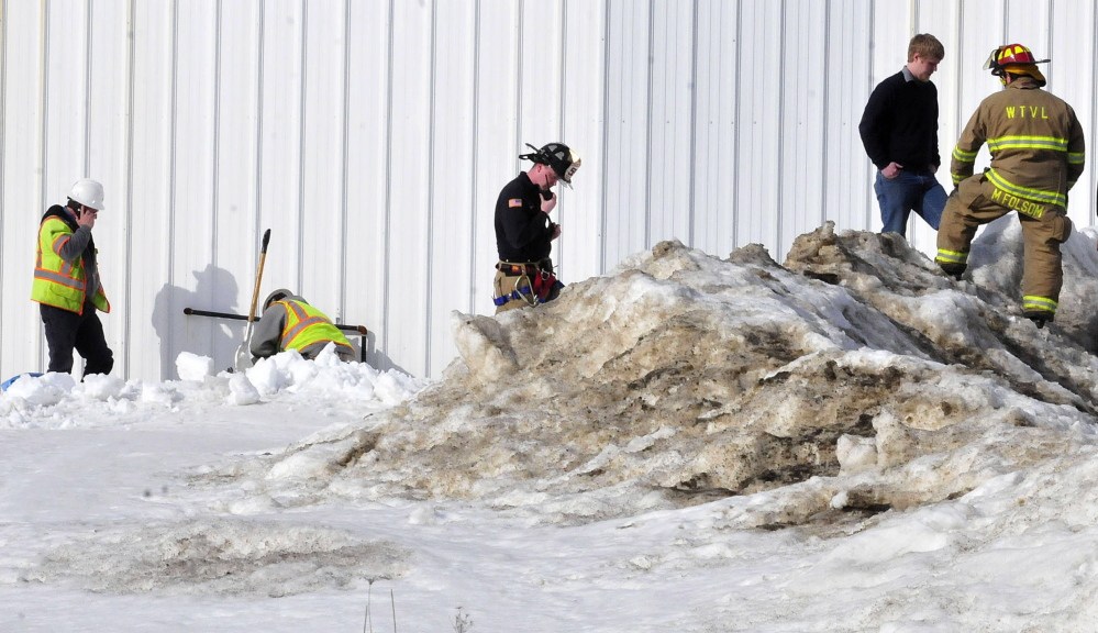 Summit Natural Gas company workers, left, shut off the gas going into the Motor Supply company building following the report of a leak on Tuesday.