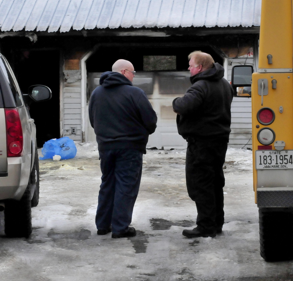 Ken MacMaster, left, of the state Fire Marshal’s Office and Bart Newhouse of the state Department of Environmental Protection investigate a fire that destroyed a home on Dinsmore Road in Sidney Monday evening.