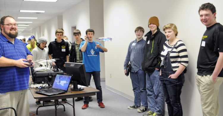 Christopher DeRaps, left, hovers an unmanned aerial vehicle Thursday for students attending the Maine Office of Information Technology’s annual Tech Night