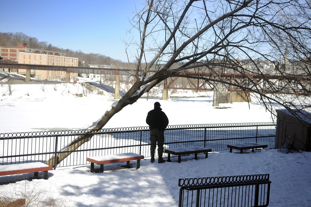 Marine Patrol Officer Clint Thompson surveys the Kennebec River on Sunday in Augusta near the spot where a woman went into the river Saturday and disappeared under the ice.