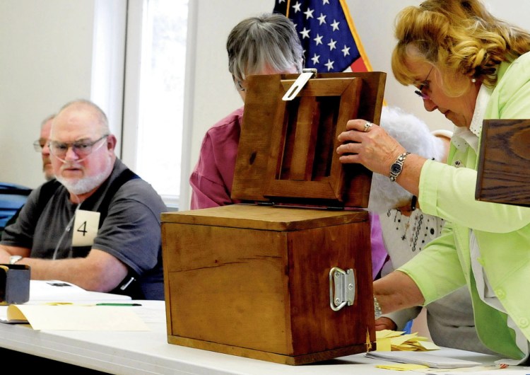 Thorndike First Selectmen Jim Bennett watches on Saturday as ballot counters determine who won elections during the Thorndike Town Meeting. For results of area town meetings, see page B3.