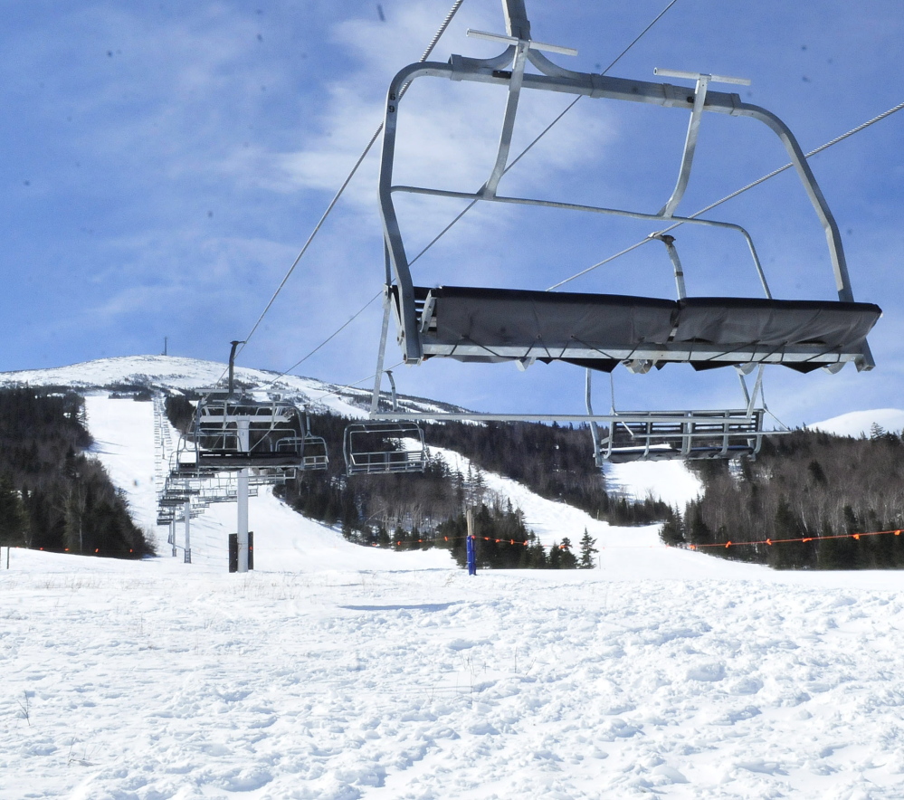 Chairs hang motionless and unused 12 feet above the snow Monday at the base of the Sugarloaf ski resport’s King Pine chairlift in Carrabassett Valley after a lift accident there on March 21.