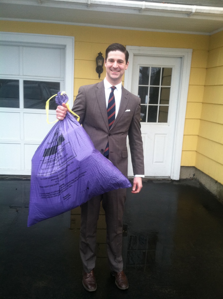 Waterville Mayor Nick Isgro, holding his city trash bag Monday, has scheduled an open community meeting next month to discuss issues relating to the city’s pay-as-you-throw trash collection program. A referendum on whether to continue the program will be held in June.