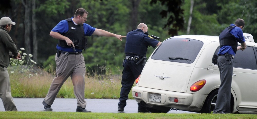 Augusta police officers surround a taxi last July after a traffic stop on Western Avenue in Augusta. William Seabron, of Brooklyn, N.Y., was arrested later on multiple charges, including drug trafficking. The proposed 2015 Augusta city budget asks for two more police detectives to help deal with crime in the city related to illegal drugs.