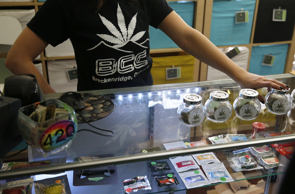 A pot store employee talks with customers inside the Breckenridge Cannabis Club, which sells recreational marijuana products, in the ski town of Breckenridge, Colo., in December. 