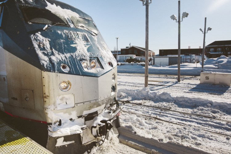 Snow sticks to a Downeaster train at the Portland Transportation Center in February. Extreme weather caused many delays this winter. State Sen. Stan Gerzofsky says he has received complaints about the service from rail riders. 2015 Press Herald file/Whitney Hayward