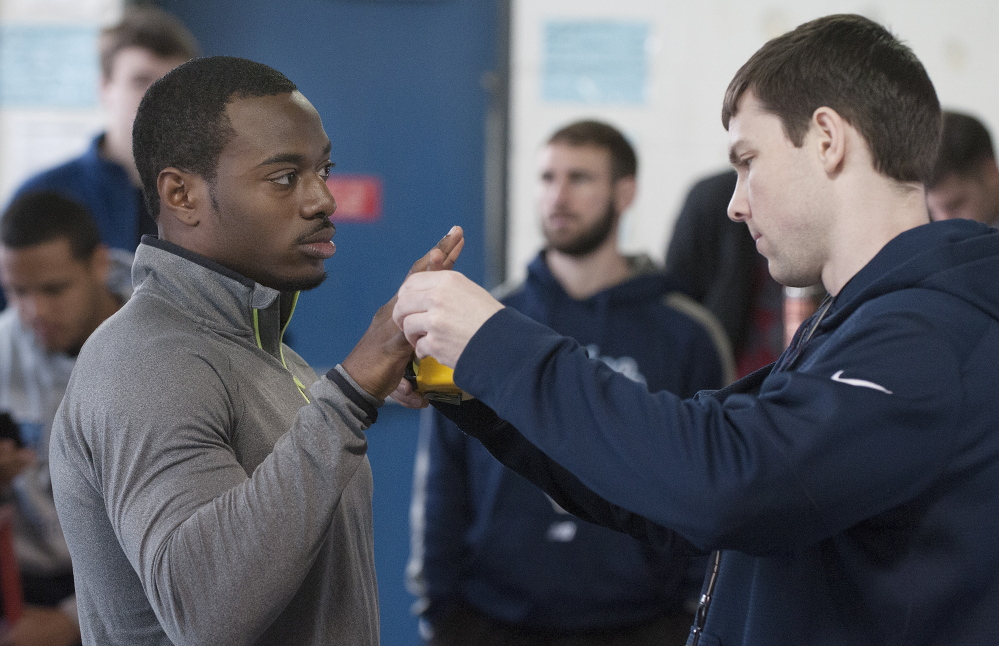 Damarr Aultman has his hand measured by Brandon Yeargan  before tests begin at Thursday’s Pro Day. Though not tall by reciever standards, Aultman can make up for it with terrific leaping ability.