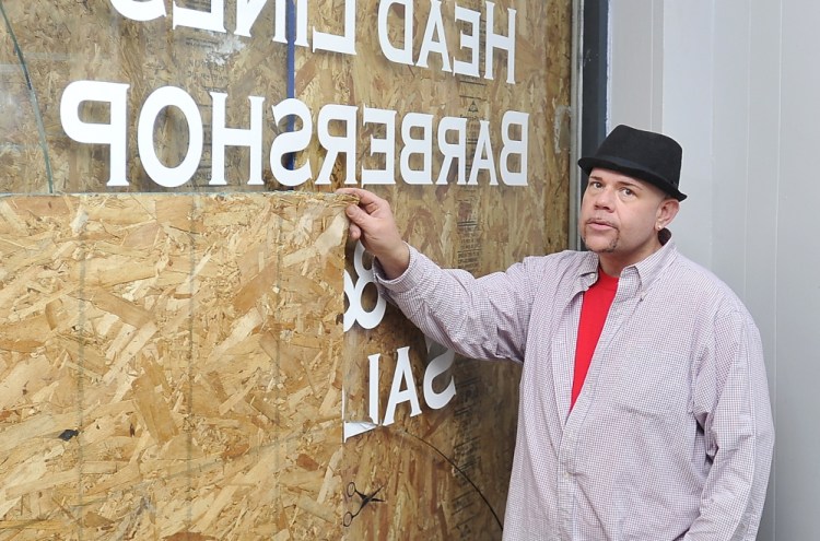 Brian McMahon, manager of Head Lines Barbershop & Salon in Biddeford, alleges Detective Sgt. John Desjardins shoved him through this window.