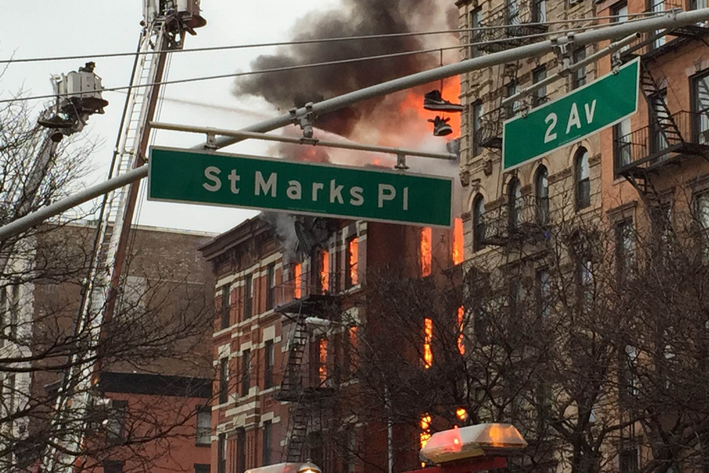 New York City firefighters work to extinguish a large fire and a partial building collapse in the East Village neighborhood of New York on Thursday.