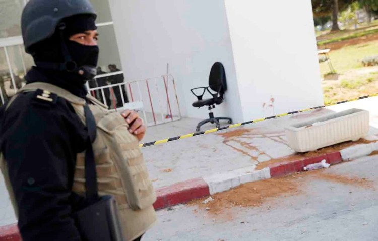 A policeman stands guard at the entrance of the National Bardo Museum in Tunis, Thursday, a day after gunmen opened fire killing more than 20 people, mainly tourists. One of the two gunmen was known to intelligence services, Tunisia's prime minister said Thursday. The Associated Press