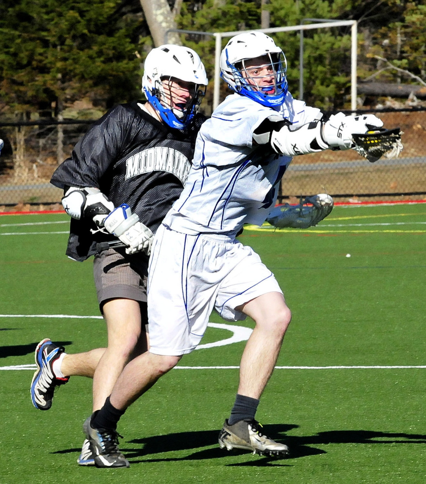 Lawrence’s Phil Gadway, right, runs with ball past Maine Central Institute’s David Andrejsin during a scrimmage at Thomas College in Waterville on Tuesday. Lawrence is fielding a varsity boys lacrosse team this spring.