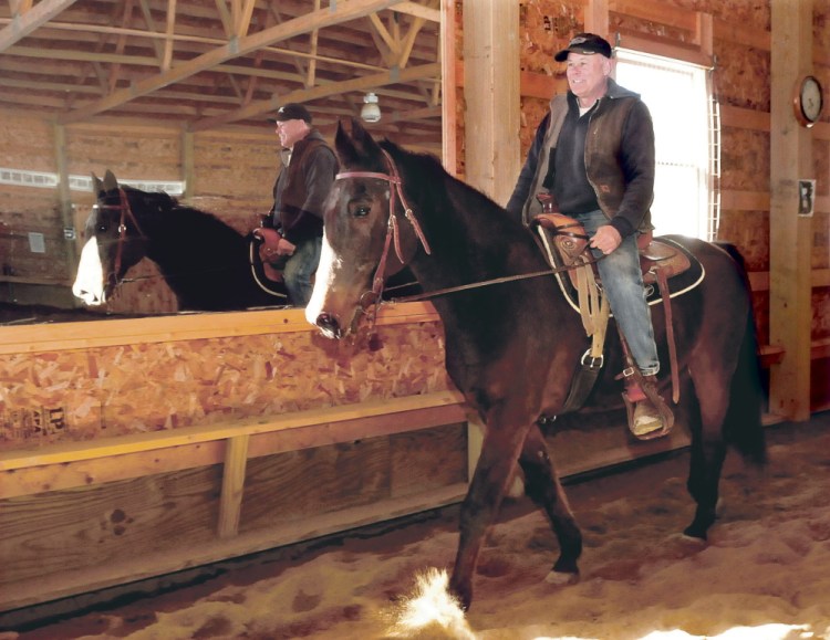 Rob Rowbottom trains former harness race horse Postcard Jack to become a saddle horse inside a riding barn in Norridgewock on March 31.