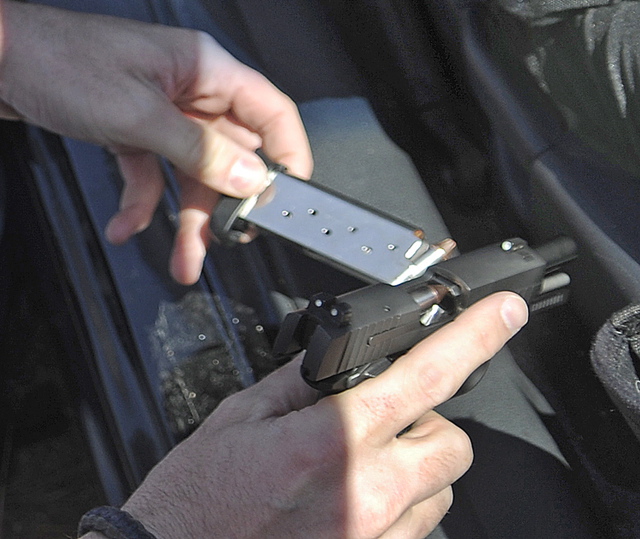 State Trooper Chris Rogers unloads a pistol recovered Wednesday from a vehicle he stopped on Interstate 95 in West Gardiner after a couple reported having a gun drawn on them while traveling in the southbound lane.