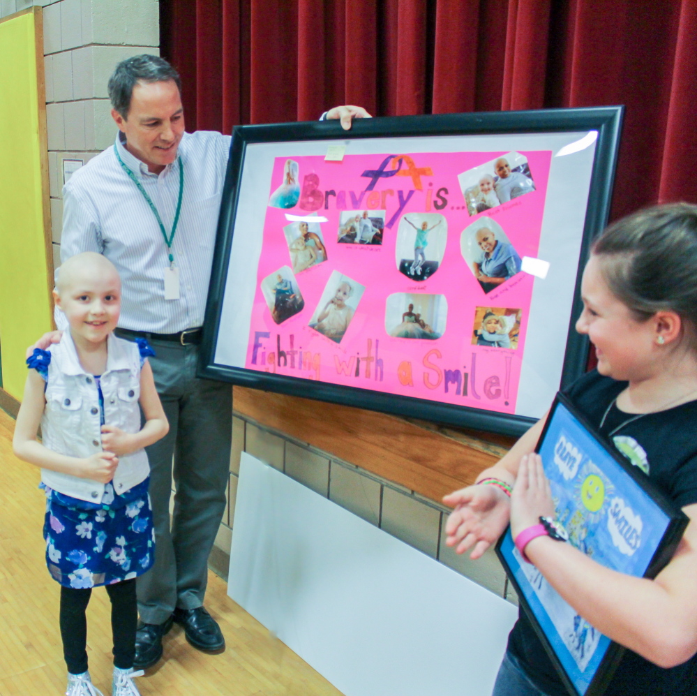 Farrington Elementary School second-grader Kendall Dorr, left, placed first in category K-3rd grade and won $500. Kristen Merrill, right, took second place in category 4th-6th grade and won $250). She is a 4th grader at Farrington Elementary School. In the center is Dr. Randall Cutri.