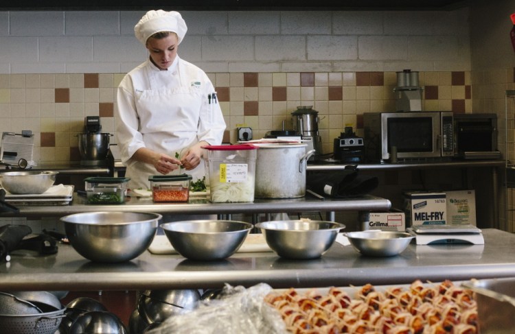 Sakara Poppas prepares ingredients for a fried rice dish in Southern Maine Community College’s culinary arts lab. In recent years, the school has added programs in computer forensics, network security and precision machining, among other things.