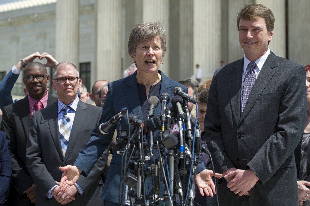 Plaintiff James Obergefell of Ohio, left, and Washington attorney Douglas Hallward-Driemeier, right, listen as civil rights lawyer Mary Bonauto, center, speaks with reporters outside the Supreme Court in Washington on Tuesday following the court’s hearing on same-sex marriage.